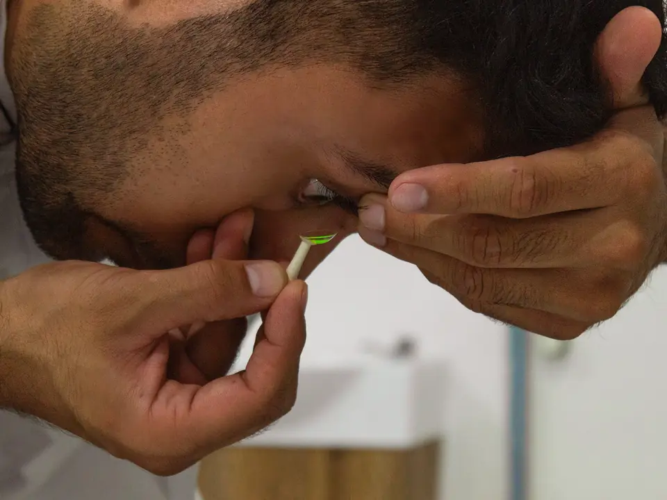 El optometrista de I Care se coloca un lente de contacto con fluoresceína