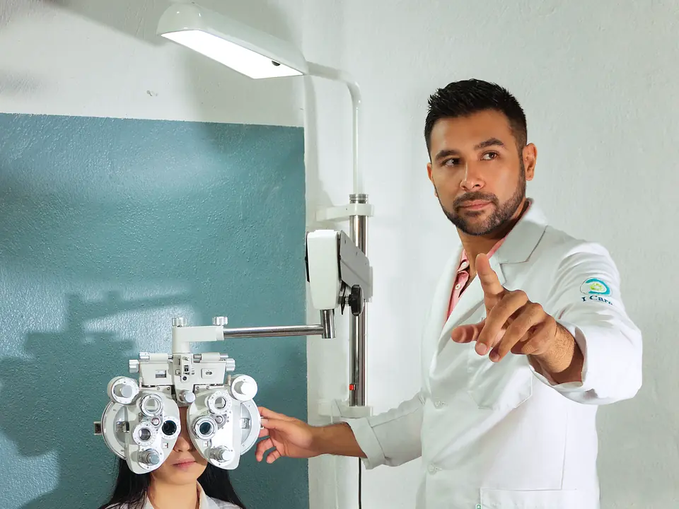 El optometrista guía un examen de la vista con foróptero