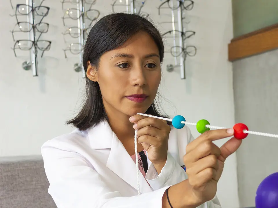 Especialista en terapia visual con un cordón de cuentas de colores